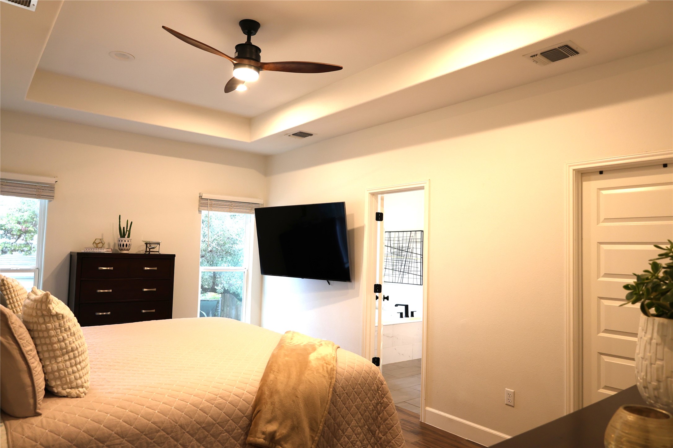 20602 Oak Ridge Lago Vista, TX 78645 - Photo 11 of 35 A spacious bedroom showcases an elegant recessed tray ceiling and warm hardwood flooring.
