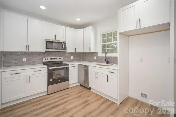a kitchen with sink a microwave and cabinets