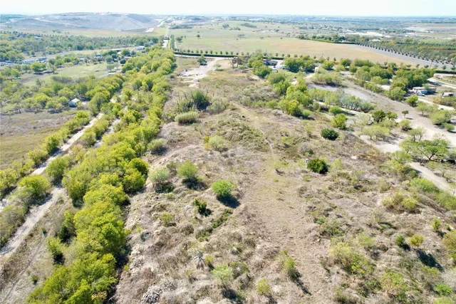a view of a field with trees in the background