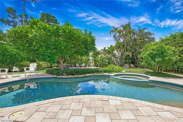 a view of swimming pool and trees in the background