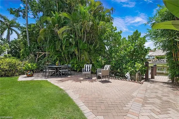 a view of backyard with a table and chairs under an umbrella