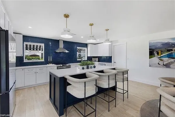 a kitchen with a sink and chairs