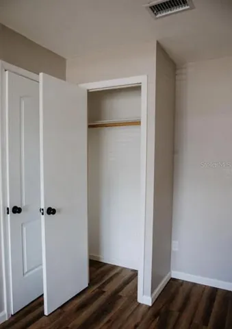 an empty room with wooden floor and closet