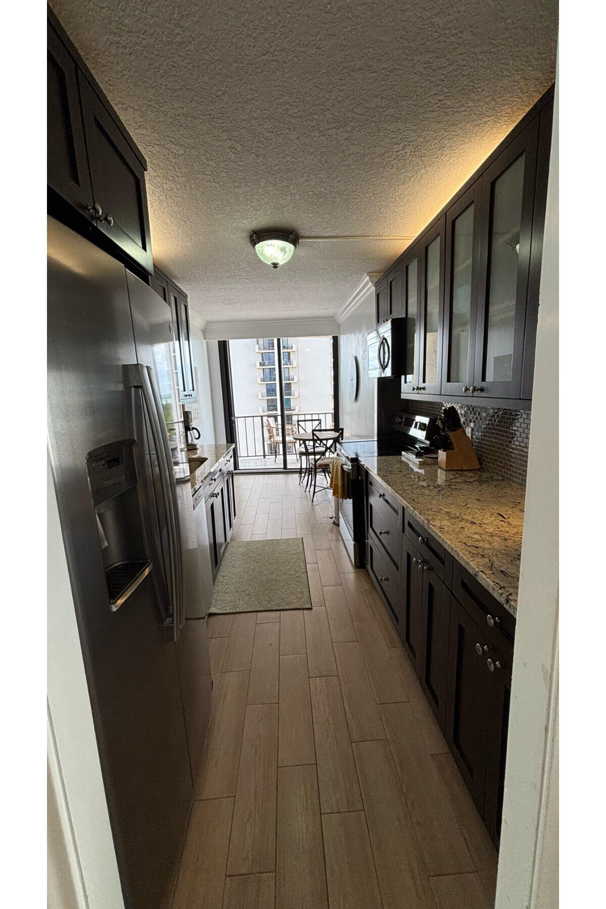 4200 North Ocean Avenue, Unit 1605 Riviera Beach, FL 33404 - Photo 13 of 19 a kitchen with stainless steel appliances granite countertop a refrigerator a stove top oven a sink and dishwasher