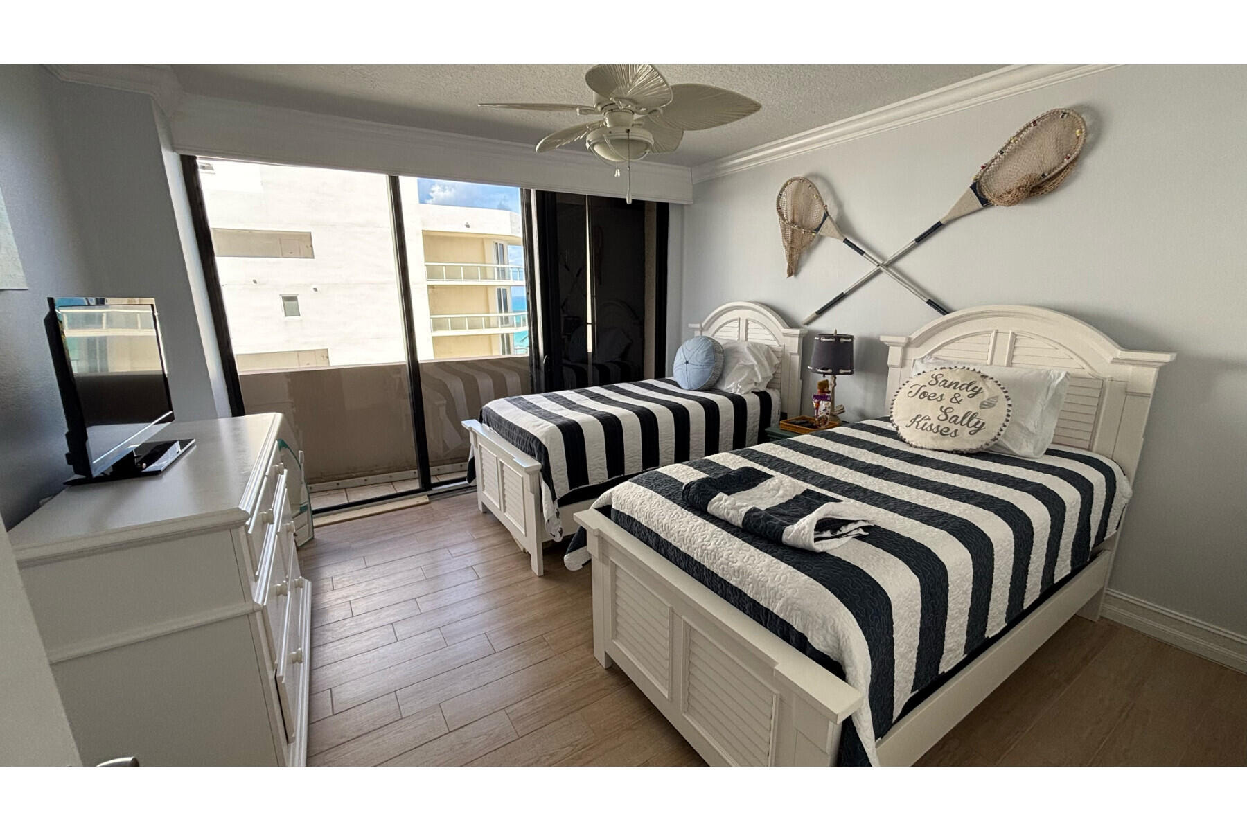 4200 North Ocean Avenue, Unit 1605 Riviera Beach, FL 33404 - Photo 19 of 19 a bedroom with two beds and a chandelier