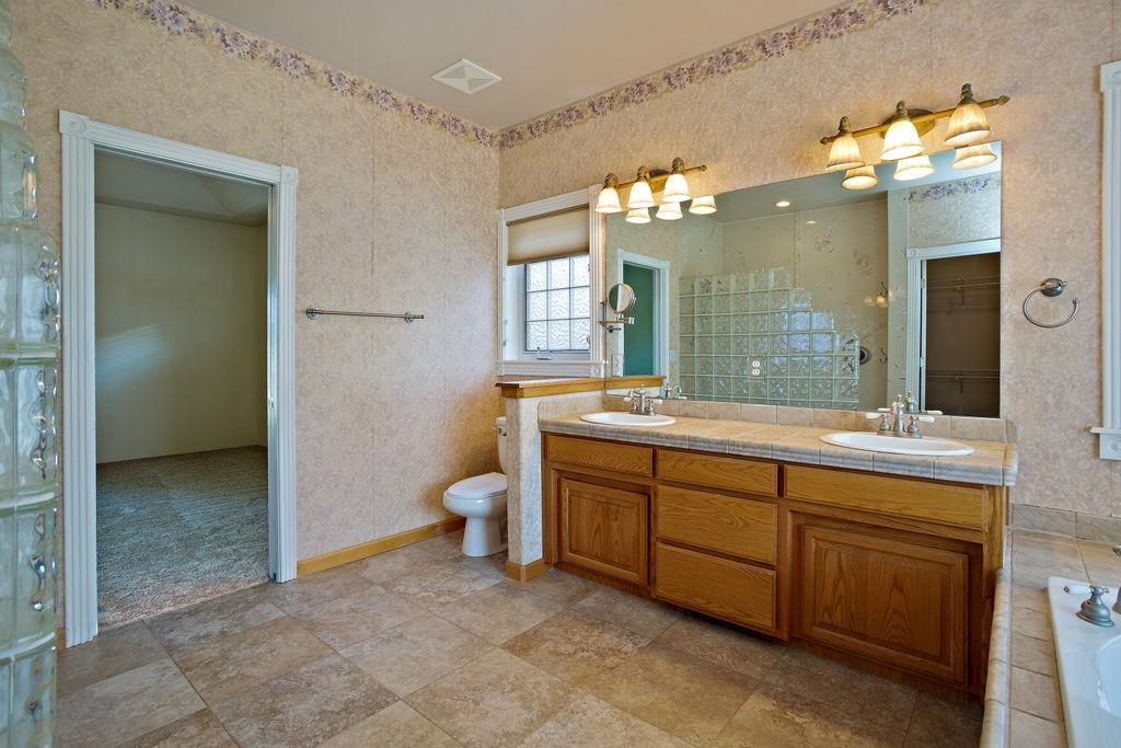 914 Ridgeview Drive Eagle Point, OR 97524 - Photo 28 of 34 a spacious bathroom with a granite countertop sink a toilet and a mirror