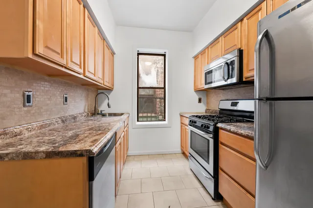 a kitchen with stainless steel appliances granite countertop a stove and a refrigerator