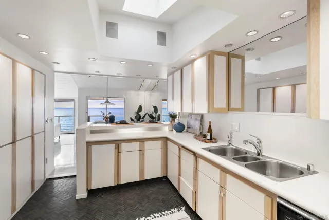 a kitchen with white cabinets sink and refrigerator