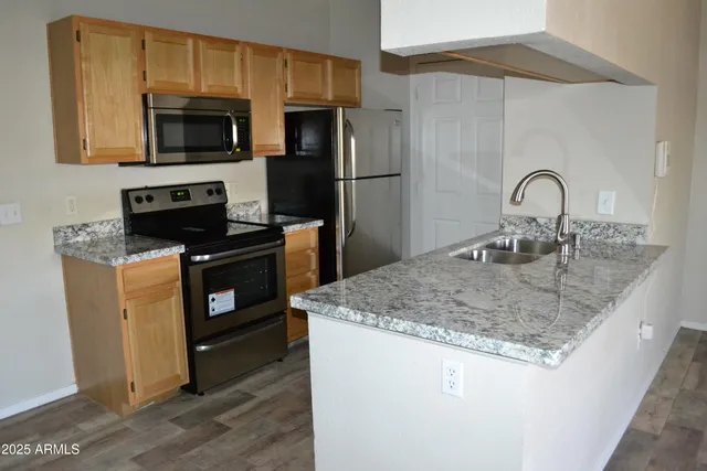 a kitchen with sink a microwave a stove and refrigerator