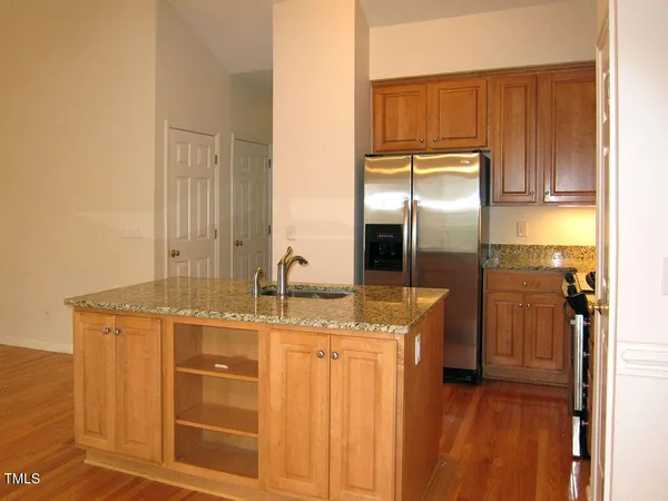 a kitchen with stainless steel appliances granite countertop a sink and a refrigerator