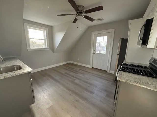 a room with wooden floor and a ceiling fan