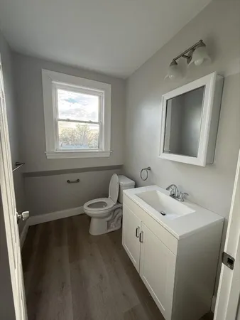 a bathroom with a toilet sink and mirror