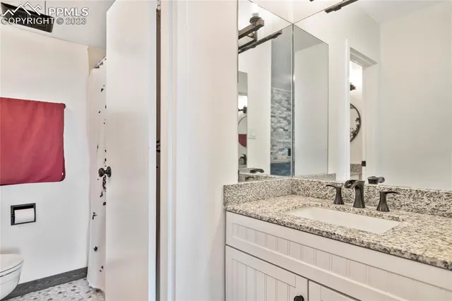a bathroom with a granite countertop sink and a mirror