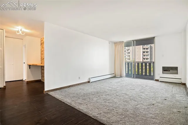 a view of an empty room with a window and a fireplace