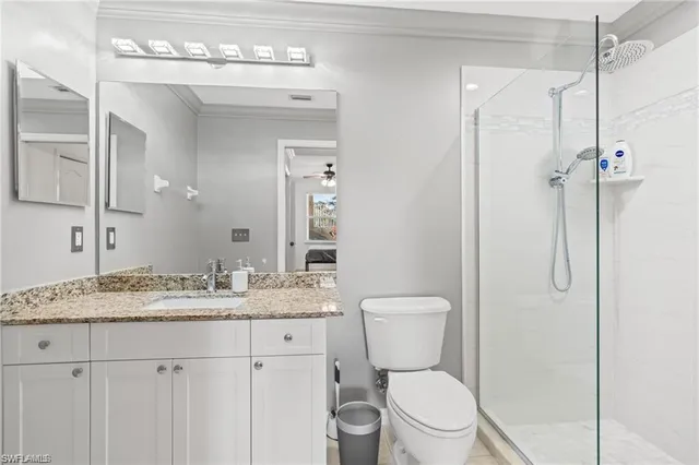 a bathroom with a granite countertop sink toilet and shower