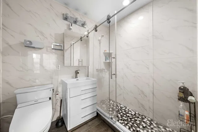 a bathroom with a sink a toilet and shower