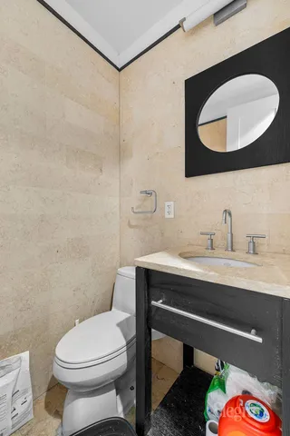 a bathroom with a toilet a sink and mirror