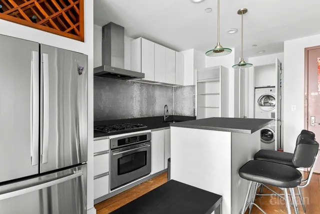 a kitchen with stainless steel appliances a stove a refrigerator and wooden cabinets