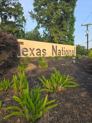 a view of a street with a white fence