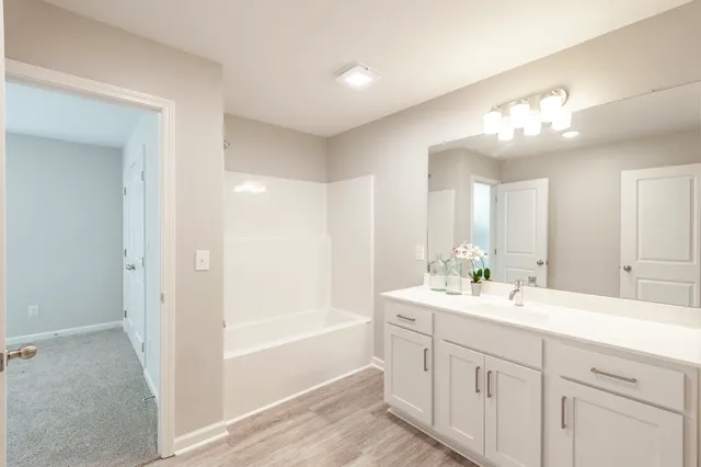 a spacious bathroom with a toilet a sink a light fixture and a mirror