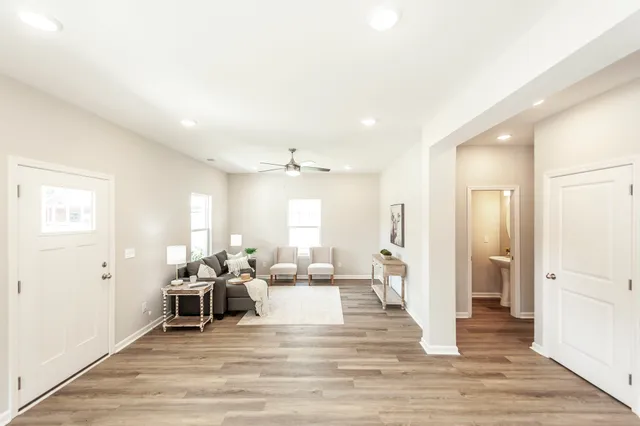 a living room with furniture and a wooden floor