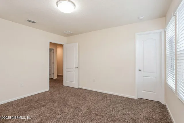 an empty room with windows and closet