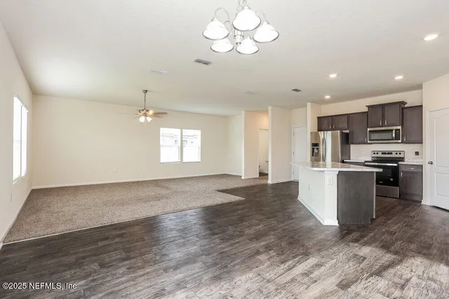 a view of kitchen with sink microwave and stove top oven