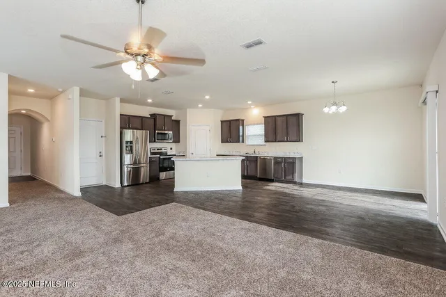a view of a kitchen with a sink and an empty room