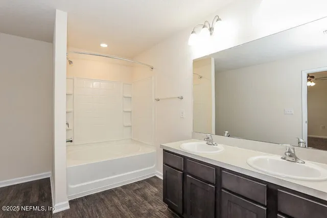 a bathroom with a tub sink and mirror