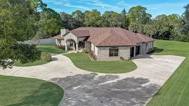 an aerial view of residential houses with outdoor space and trees