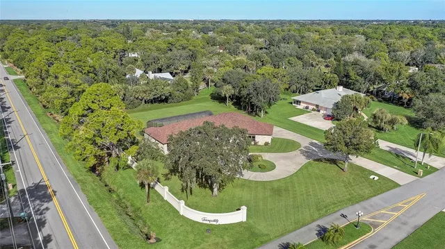 an aerial view of residential houses with outdoor space and trees