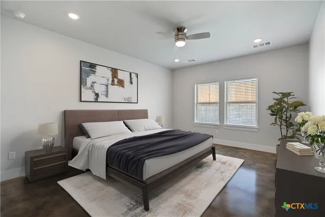 a spacious bedroom with a bed and a chandelier