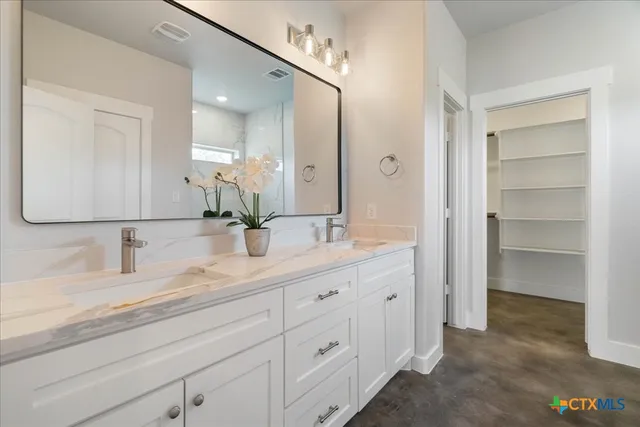 a bathroom with a double vanity sink and a mirror