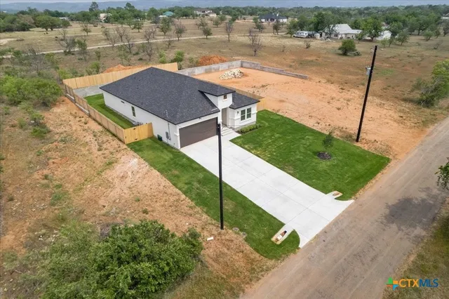 an aerial view of a house with a yard and lake view