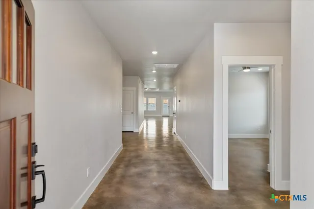 a view of a hallway with wooden floor