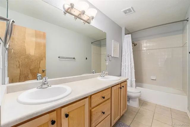 a bathroom with a granite countertop sink a toilet a mirror and shower