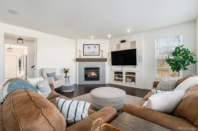 a living room with furniture a flat screen tv and a fireplace