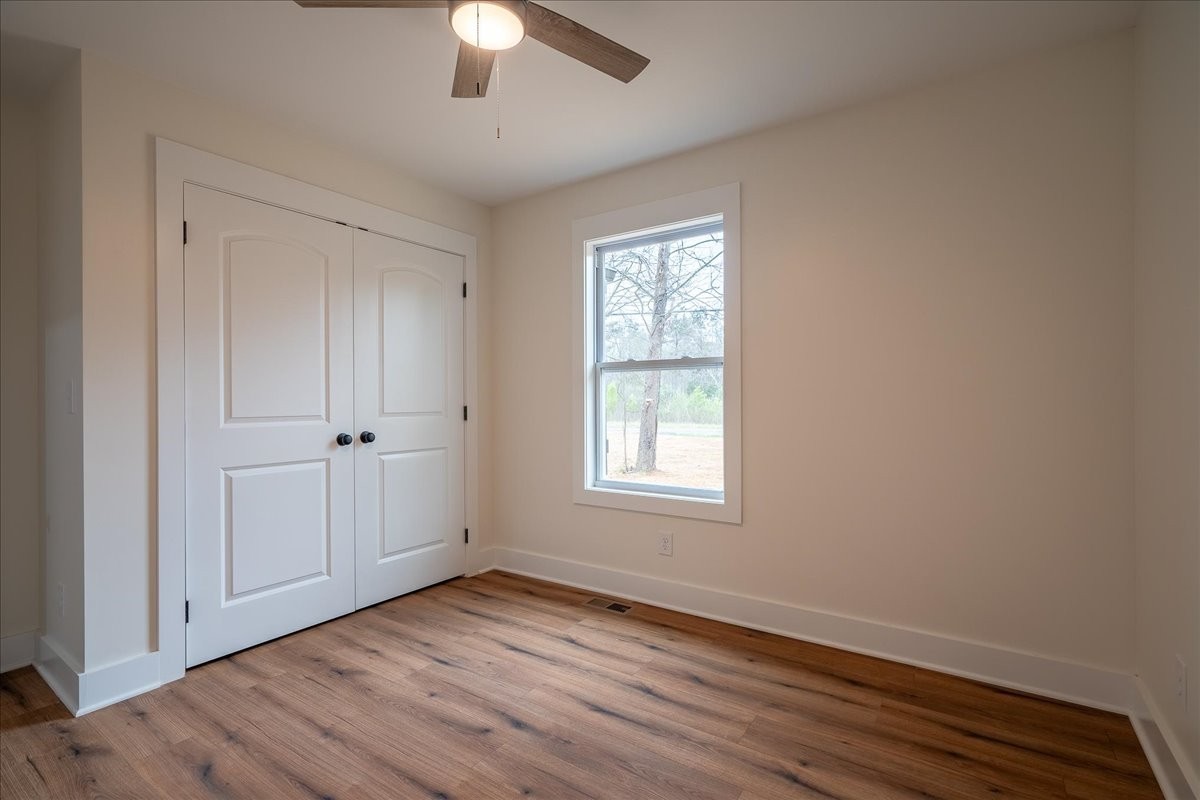3987 Buffalo Road Summertown, TN 38483 - Photo 13 of 26 an empty room with wooden floor cabinet and windows