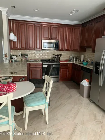 a kitchen with granite countertop a table chairs stove top oven and cabinets