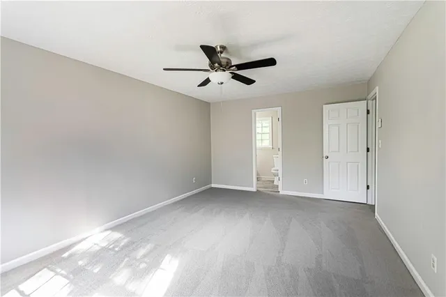an empty room with wooden floor ceiling fan and windows