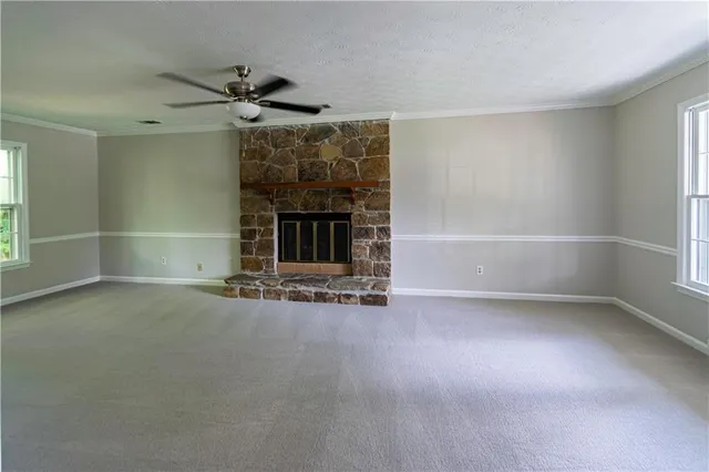 an empty room with fireplace and windows