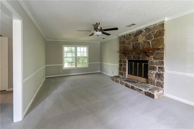 an empty room with fireplace and windows