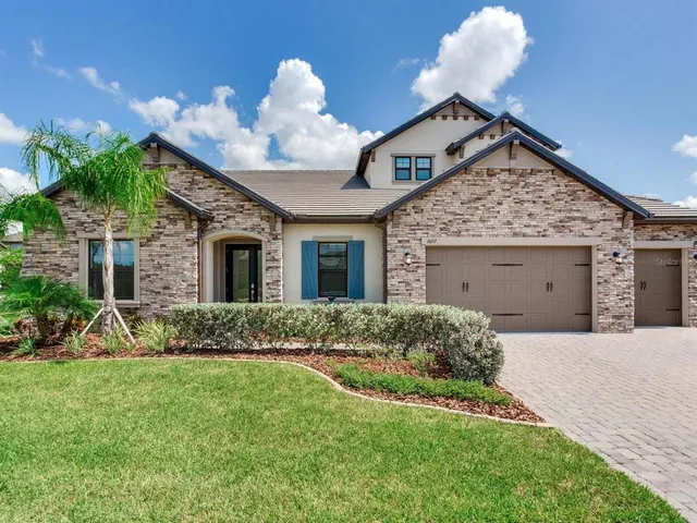 a front view of a house with a garden and plants