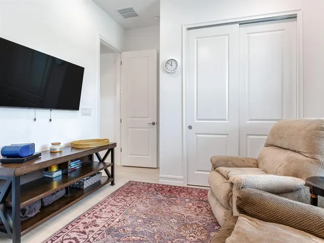 a bedroom with a bed and a lamp on dresser