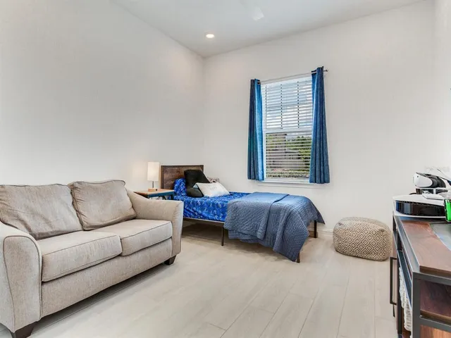 a view of a hallway with wooden floor and furniture