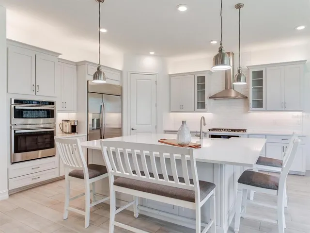 a bathroom with a double vanity sink and mirror with bathtub