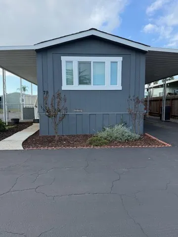 a front view of a house with yard and parking