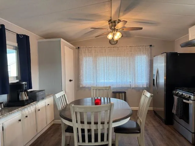 a kitchen with a dining table chairs and white appliances