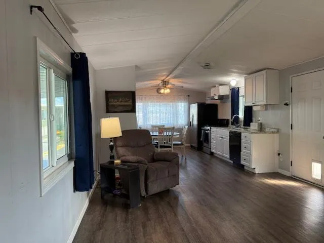 a living room with furniture and kitchen area