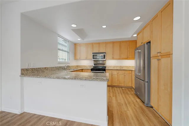 a kitchen with a refrigerator a sink and wooden floor